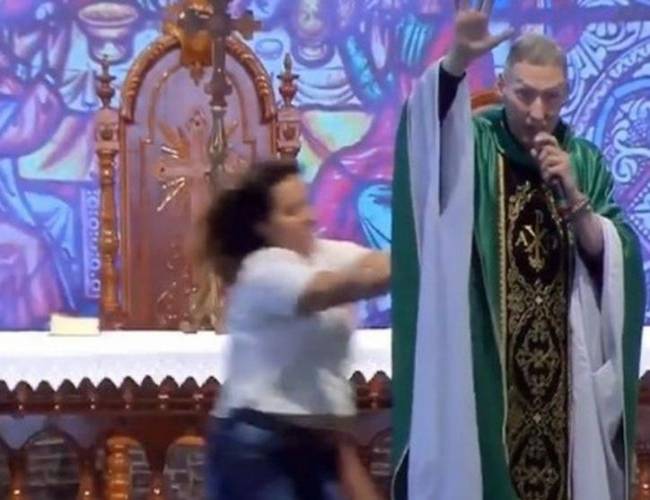 (VIDEO) Mujer sorprende y empuja a sacerdote mientras oficiaba misa