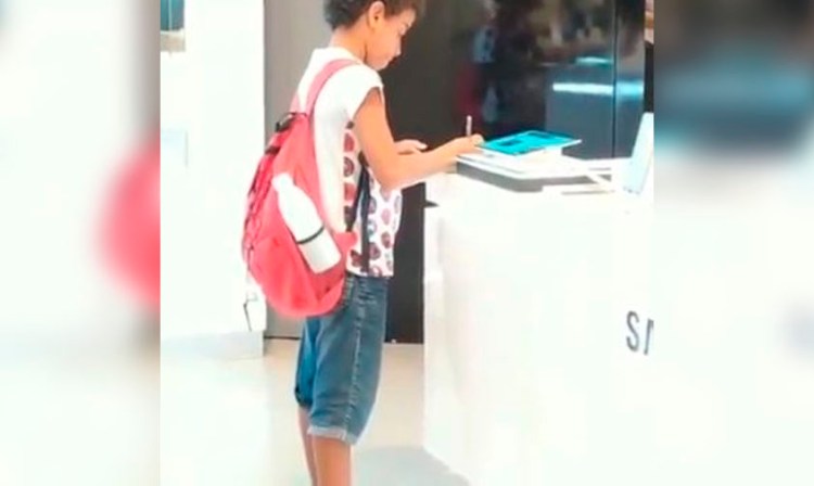 Para terminar su tarea, niño usa una tablet de exhibición
