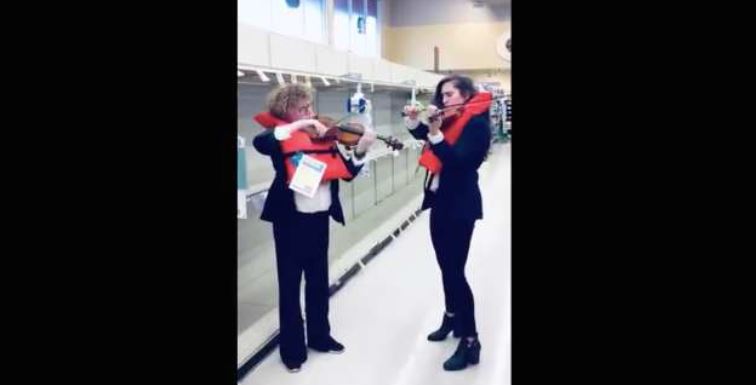 Violinistas tocan tema del “Titanic” frente estantes vacíos de papel higiénico