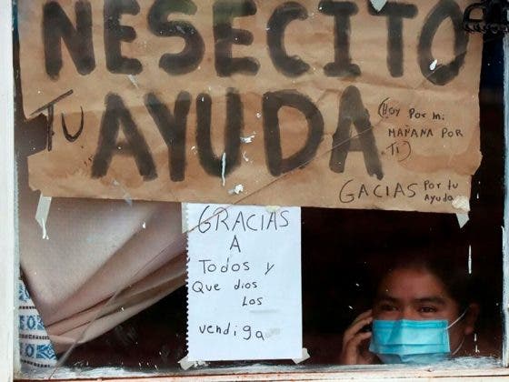 Familia enferma de Covid-19 pide ayuda con carteles desde su ventana